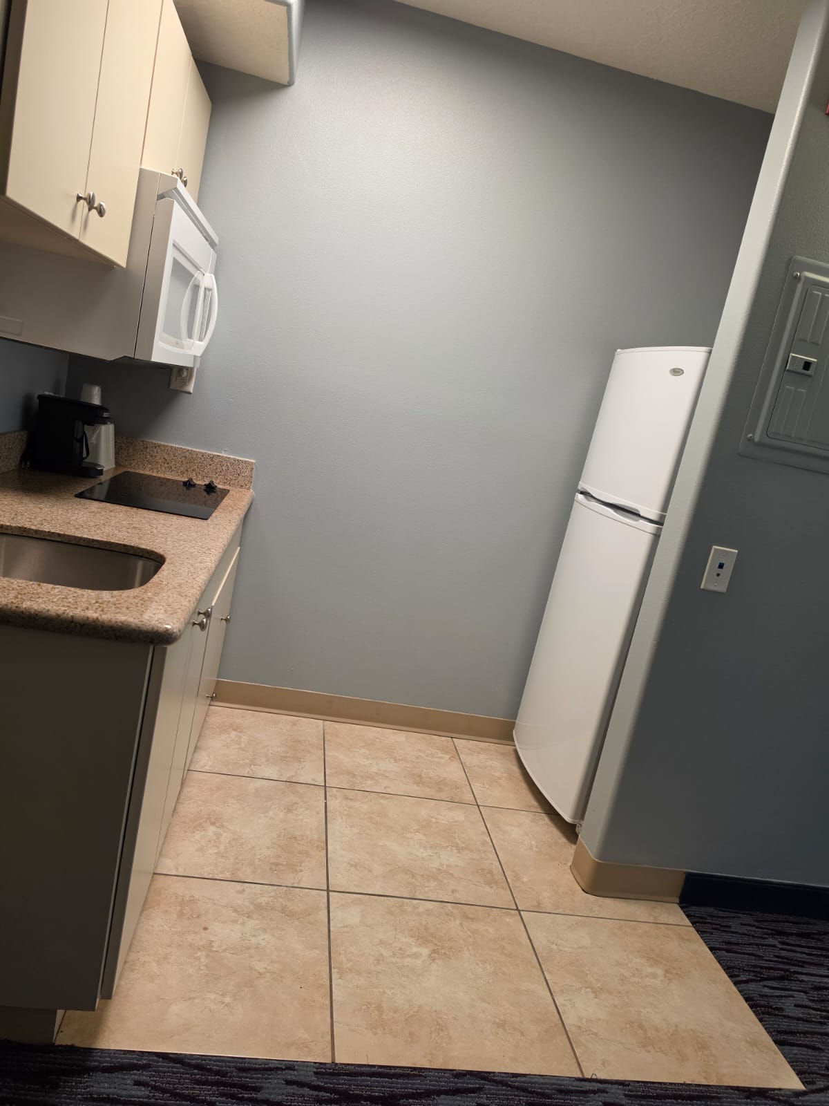 Kitchenette with cooktop, sink, cabinets and full-height refrigerator — Best Western Vernal Inn, Vernal Utah