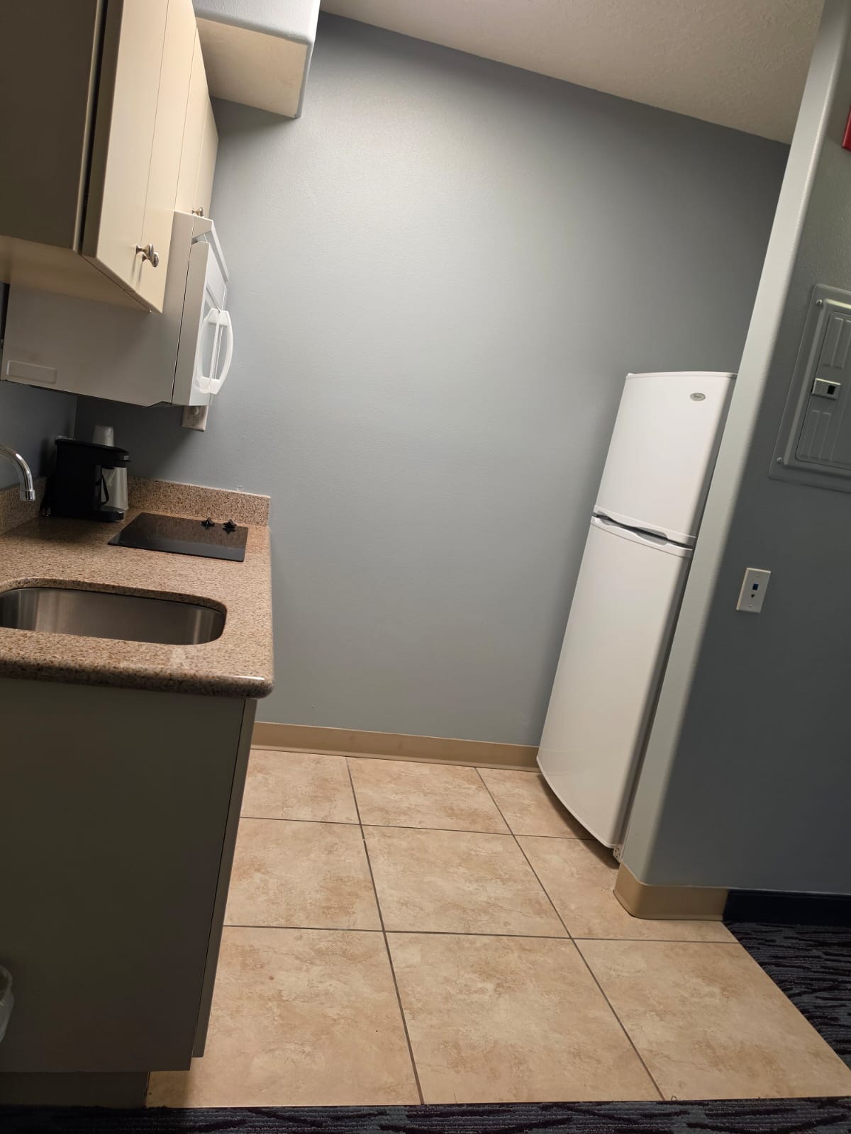 Kitchenette with cooktop, sink, cabinets and full-height refrigerator — Best Western Vernal Inn, Vernal Utah