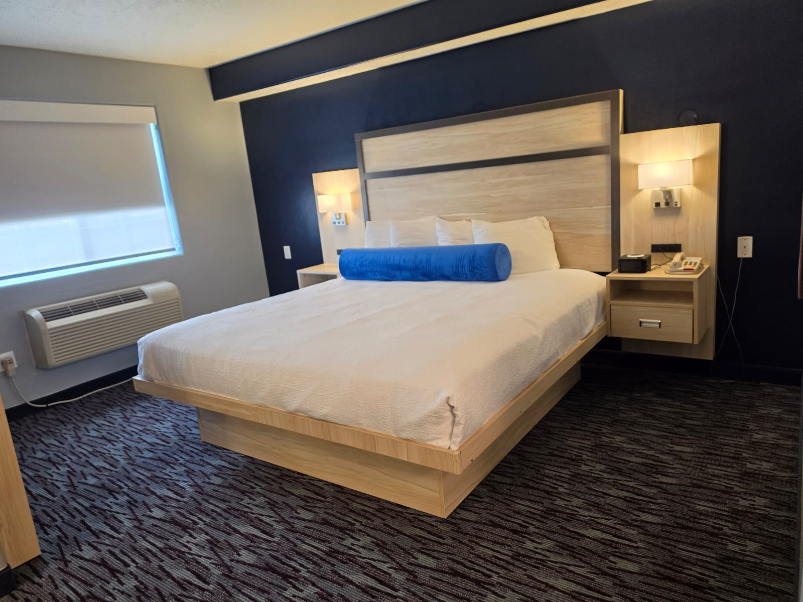 King bed beside a shaded window and heating and cooling unit — Best Western Vernal Inn, Vernal Utah