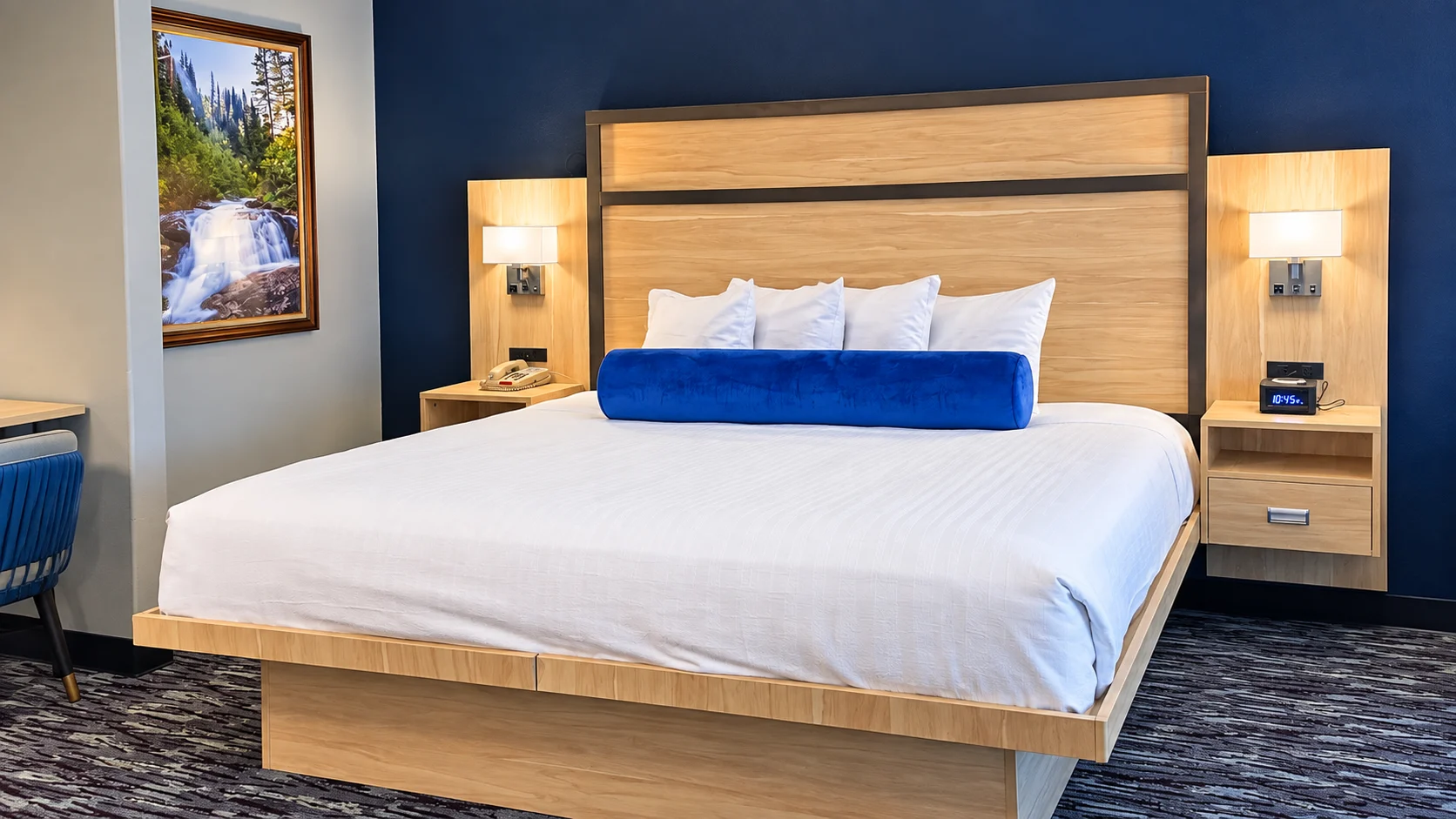 King bed with panelled headboard and wall reading lights against a navy wall — Best Western Vernal Inn, Vernal Utah