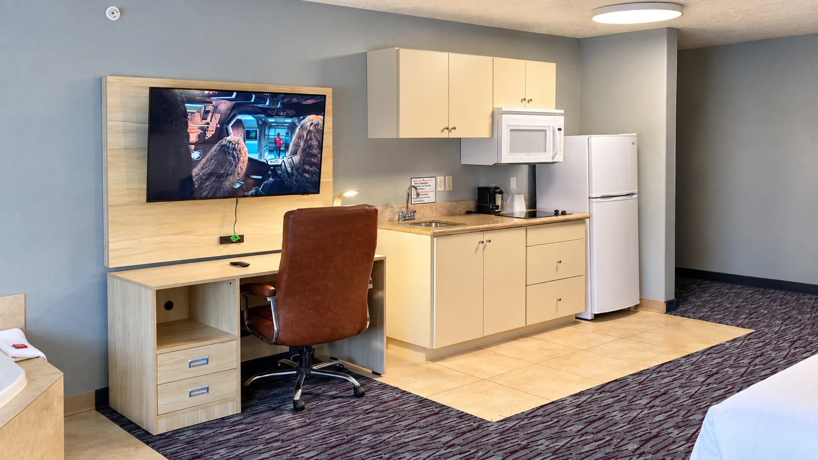 Desk with leather office chair and wall-mounted TV beside the kitchenette — Best Western Vernal Inn, Vernal Utah