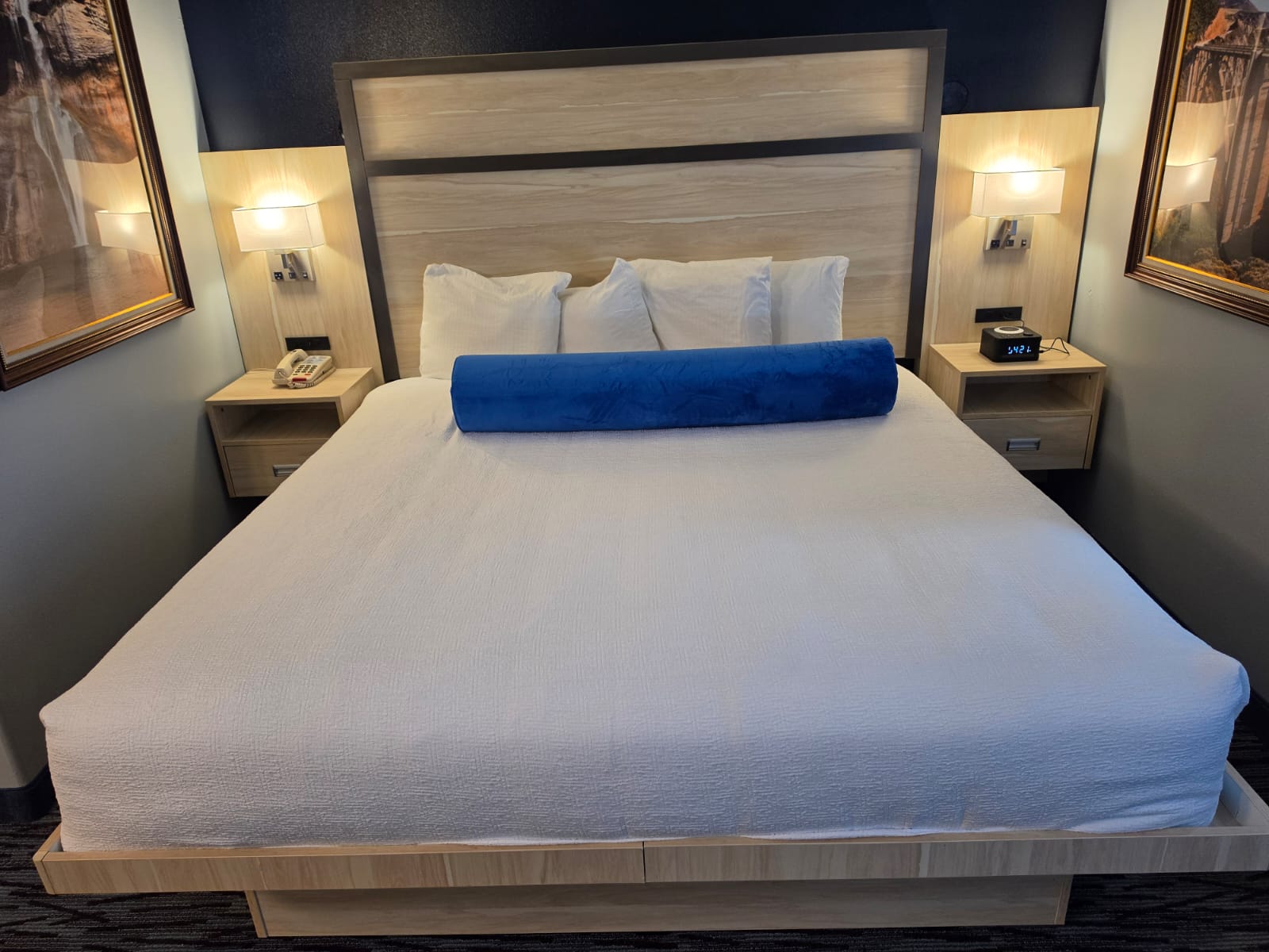 King bed with panelled headboard and wall reading lights in a Studio King room — Best Western Vernal Inn, Vernal Utah