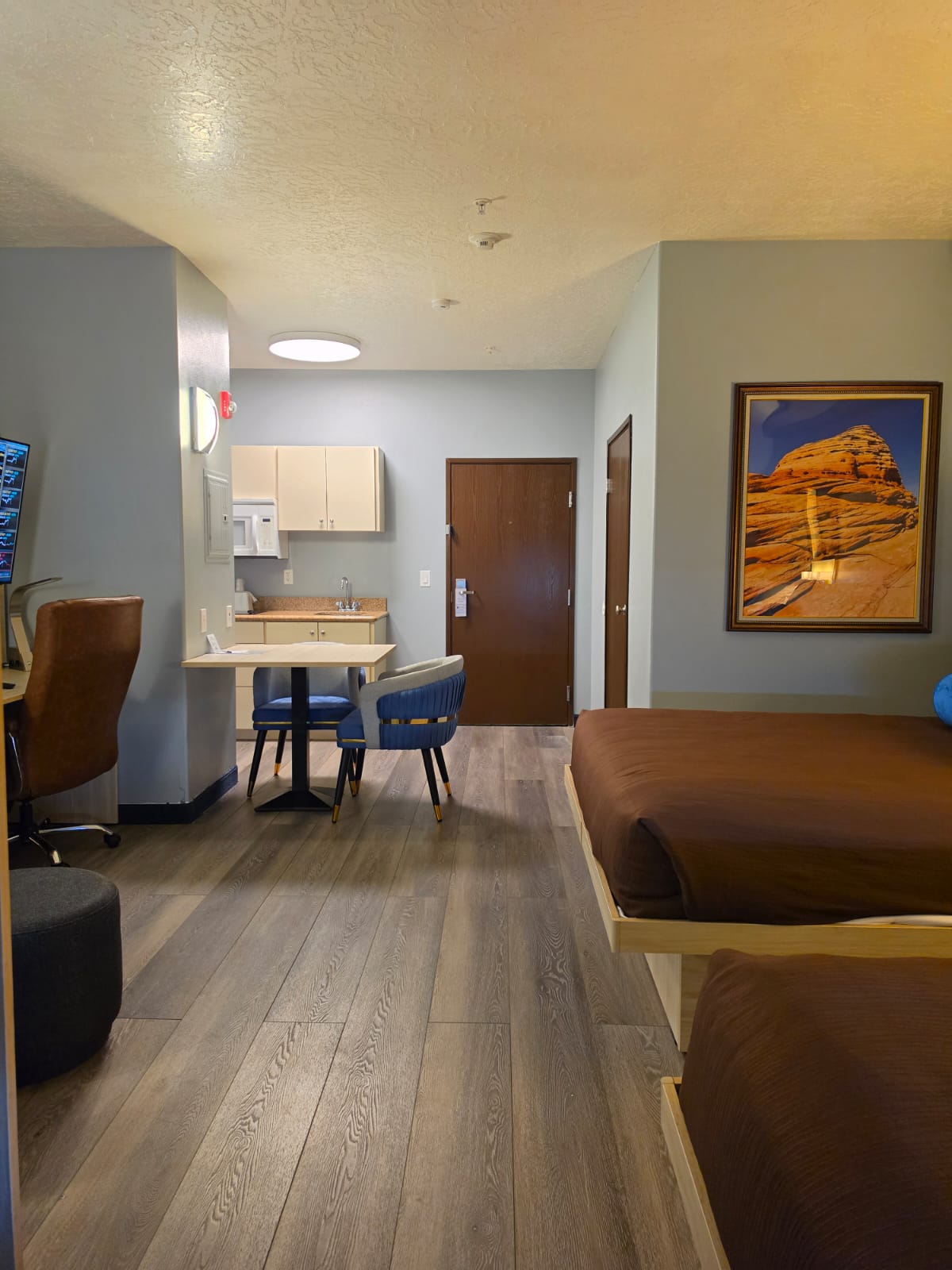 Full view of a pet-friendly studio showing entrance, kitchenette, dining table and wood-style floors — Best Western Vernal Inn, Vernal Utah