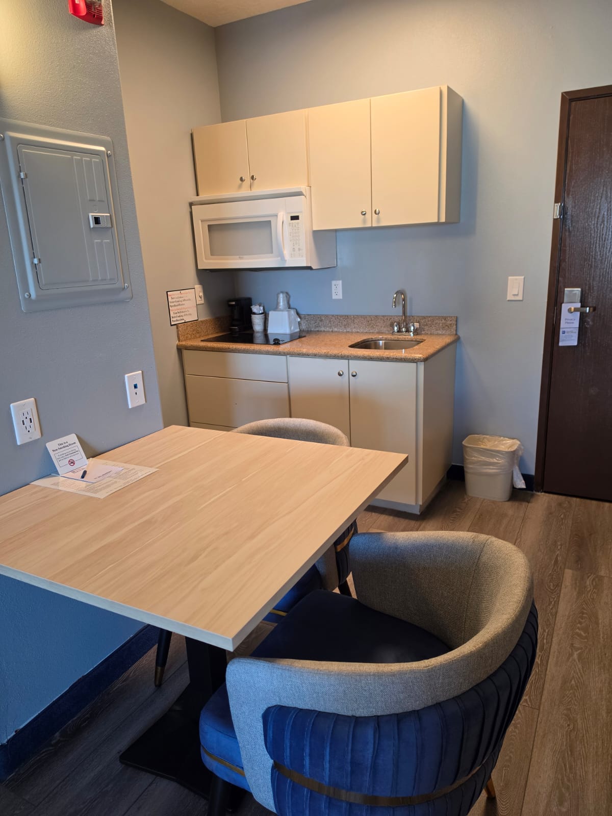 Kitchenette with cooktop, sink and cabinets beside a dining table — Best Western Vernal Inn, Vernal Utah